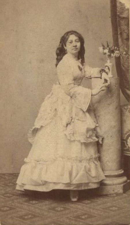 Clara Selmo Zemlinsky en robe blanche debut accoudée à une colonne